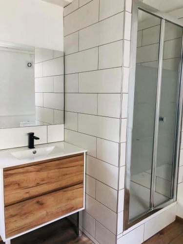 une salle de bain avec un lavabo et une douche en verre dans l'établissement Maison atypique au pied de l'Eglise St Géry, à Cambrai