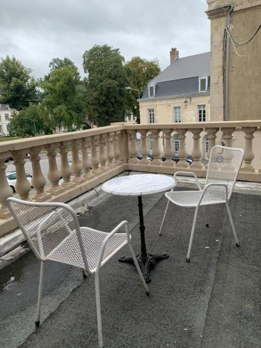 deux chaises et une table sur un balcon dans l'établissement Maison atypique au pied de l'Eglise St Géry, à Cambrai