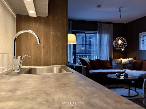 a kitchen with a sink and a living room at Lindvallen Ski Resort Pool and Padel - Sauna - 6 Guests in Sälen