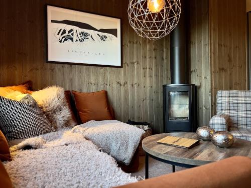 a living room with a couch and a fire place at Lindvallen Ski Resort Pool and Padel - Sauna - 6 Guests in Sälen