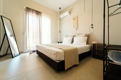 a bedroom with a bed and a large window at Styliani's Cozy Apartment in Iraklitsa