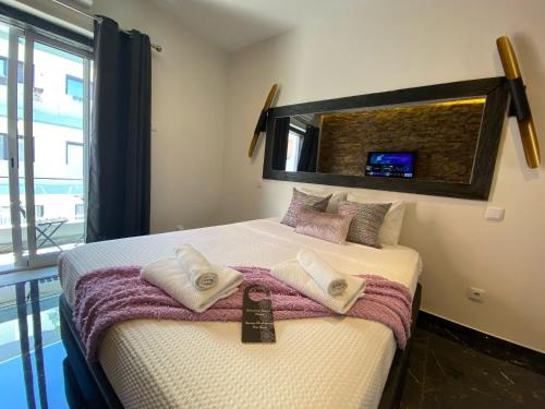 a bedroom with a bed with towels on it at AL Barbinha in Faro