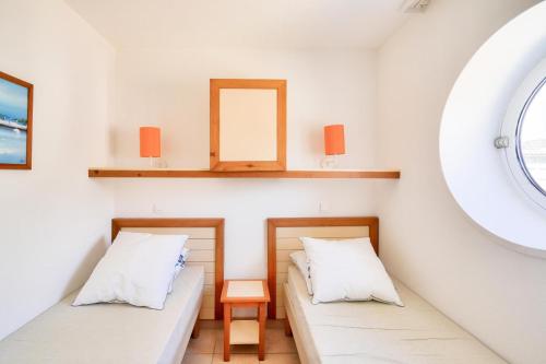 two beds in a room with a mirror at Le Phare de Trescadec - maeva Home - 2 Pièces 4 Personnes Sélection MAE-3559 in Audierne