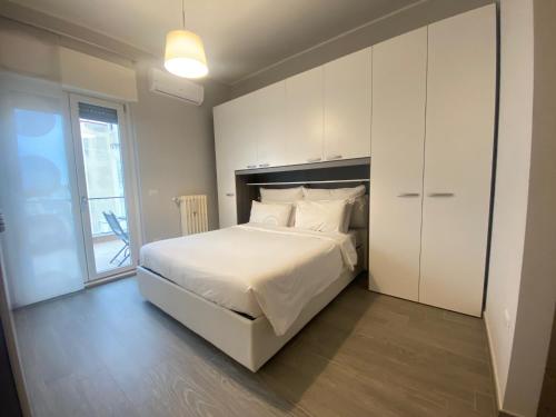 a bedroom with a large white bed and a window at Casa Orsini Vista Mare -Manfredi Homes&Villas in Manfredonia