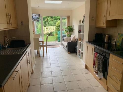 a kitchen with a tiled floor and a living room at Lovely riverside cottage, Weybridge, Surrey in Weybridge
