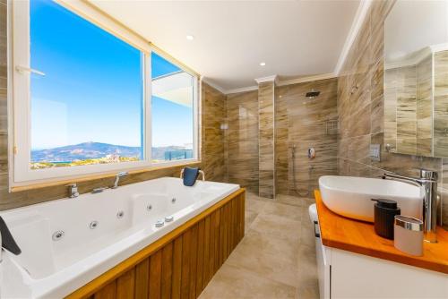 ein Badezimmer mit großer Badewanne und großem Fenster in der Unterkunft villa kayras-1 in Bezirgân
