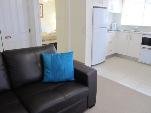 a black couch with a blue pillow in a kitchen at Costa D'Ora Holiday Apartments in Gold Coast