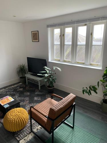 a living room with a couch and a table at Glastonbury town centre modern apartment in Glastonbury