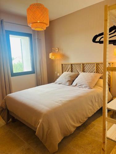 une chambre avec un grand lit et une fenêtre dans l'établissement Le Mas de Sandre, en campagne, à Châteaurenard