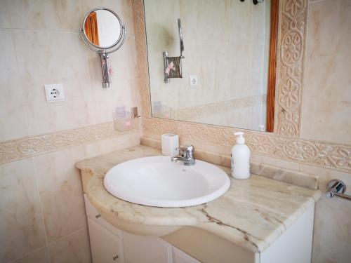 a bathroom with a white sink and a mirror at Chalet Campoamor con piscina privada in Orihuela Costa