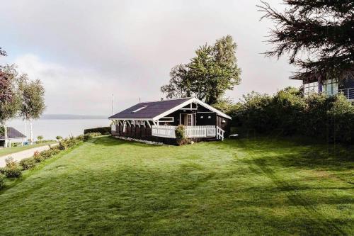 a house sitting on top of a lush green yard at Holiday Home With Fjord Views In Hjarbæk in Løgstrup
