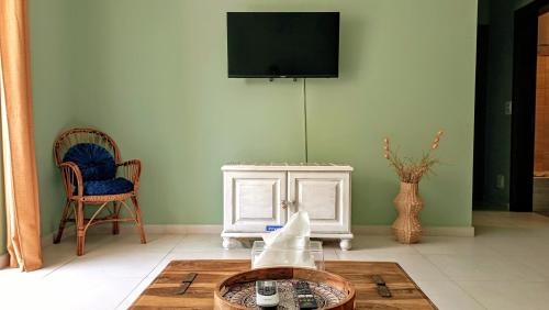 a living room with a tv and two chairs and a table at Home from home at the Seacrest in St Paul's Bay