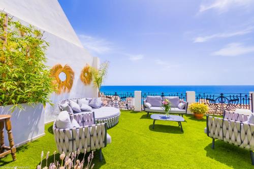 un patio con muebles y el océano en el fondo en MIMAR ALTEA SOL Exclusive, en Altea