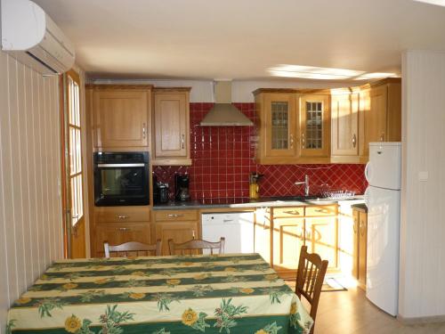 Il comprend une cuisine avec une table et des placards en bois. dans l'établissement Gite PROVENCE MONT VENTOUX, à Malemort-du-Comtat