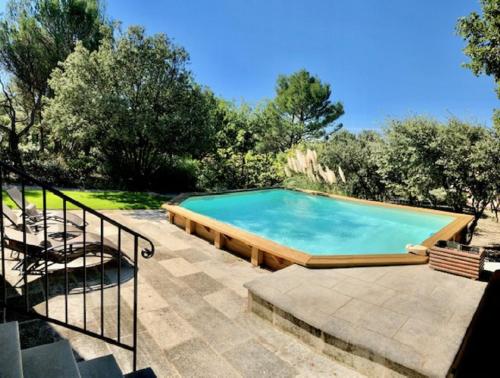 une grande piscine dans une cour avec un escalier dans l'établissement Gite PROVENCE MONT VENTOUX, à Malemort-du-Comtat