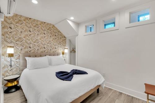 Un dormitorio con una gran cama blanca y ventanas. en Marigny Hideaway Across From French Quarter, en Nueva Orleans