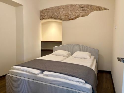 Un dormitorio con una cama con una pared de piedra. en Pilies8 Luxury Vilnius Apartment, en Vilna