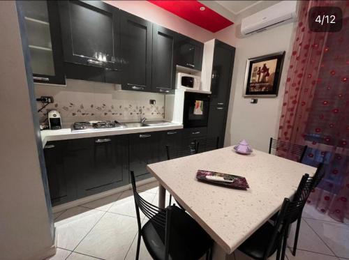 a kitchen with black cabinets and a table with chairs at Casa Primavera in Mozzate
