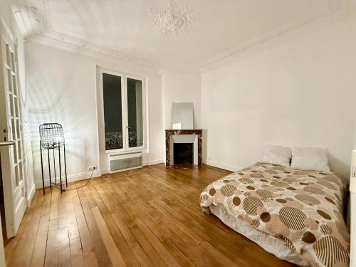 une chambre blanche avec un lit et une cheminée dans l'établissement Charmant appartement proche Paris, à Villeneuve-Saint-Georges