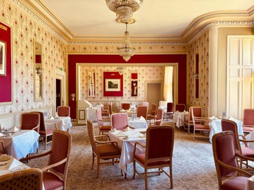 a dining room with tables and chairs and a chandelier at Dryburgh Abbey Hotel in Melrose