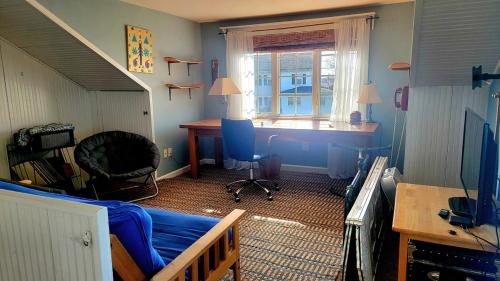 een kamer met een bed, een bureau en een raam bij Enchanted Cottage 1 block to beach in Madison