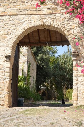 an archway in a stone building with a cat sitting under it at Sa Domu de sa Contissa in Sèlegas