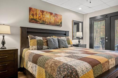ein Schlafzimmer mit einem Bett und einem Gemälde an der Wand in der Unterkunft Secluded~ 3 Kings~ Games~ Hot Tub + Fire Pit~ Pets in Cove Creek Cascades