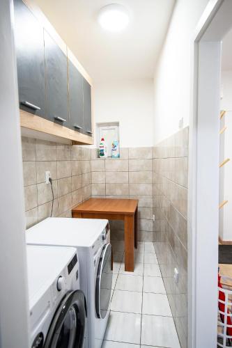 a laundry room with a washing machine and a table at Platanus City Center in Trebinje