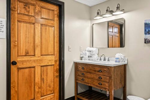 ein Badezimmer mit Waschbecken und Holztür in der Unterkunft Secluded~ 3 Kings~ Games~ Hot Tub + Fire Pit~ Pets in Cove Creek Cascades
