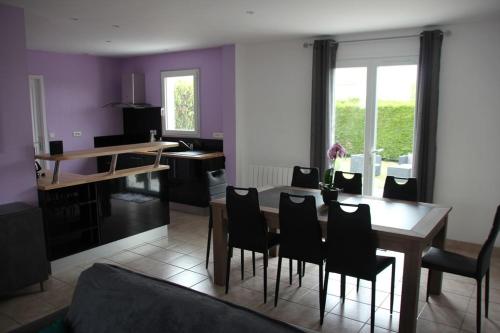 une cuisine et une salle à manger avec une table et des chaises dans l'établissement Maison familiale Ile d'Oléron, à Saint-Georges-dʼOléron