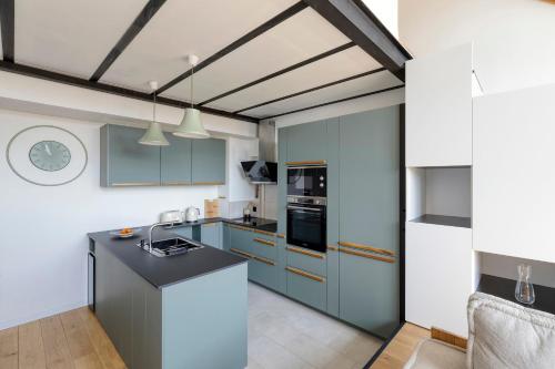 une cuisine avec des armoires bleues et un comptoir noir dans l'établissement Appartement Jacquard - Welkeys, à Le Pré-Saint-Gervais