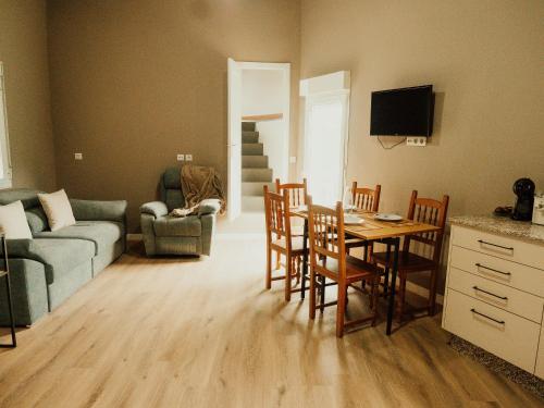 a living room with a couch and a table and chairs at Casa El Refugio in Monforte de Lemos