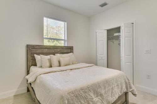 a bedroom with a bed with white sheets and a window at Day Trip to Beach and Manatee Park Lehigh Acres Gem in Lehigh Acres