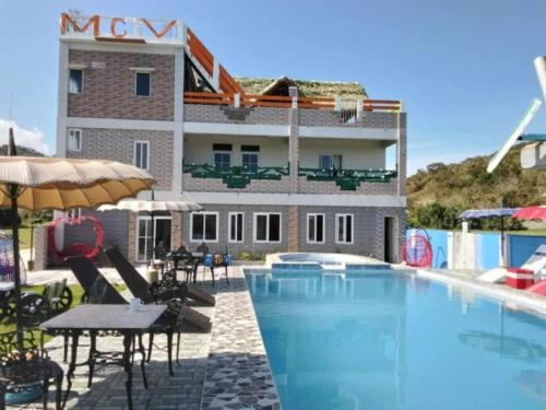 a hotel with a swimming pool in front of a building at Mountain cove villa in Pagudpud