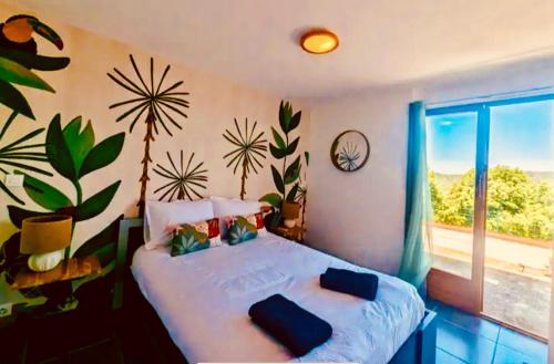una camera da letto con due letti e una grande finestra di Maison avec piscine VIVES 8 couchages 4 chambres a Vivès