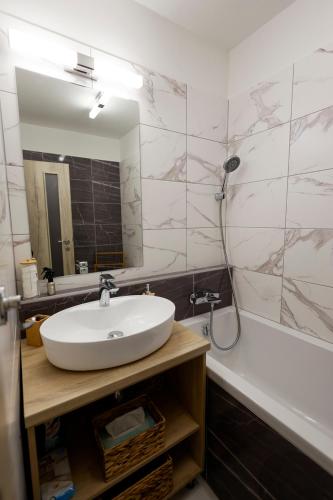 a bathroom with a sink and a mirror and a tub at Panorama Residence - Samorin near X-Bionic sphere in Šamorín