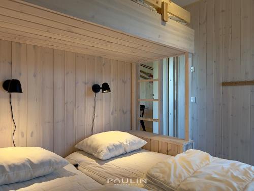 a bedroom with two beds and two lights on the wall at Lindvallen Ski Resort Pool and Padel - Sauna - 7 Guests in Sälen