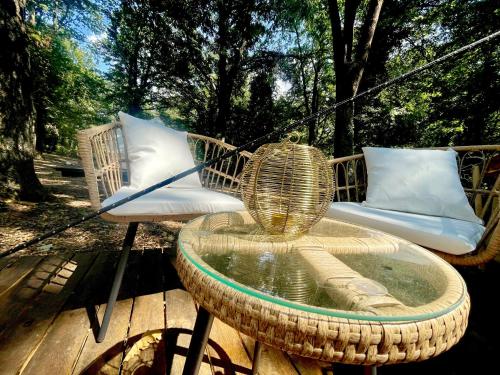 a wicker table and chairs on a wooden deck at OAK Glamping Relax in Manziana