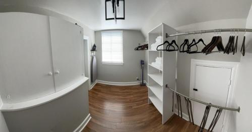 a hallway with white walls and a hallway with shoes on shelves at The Nest in Mobile