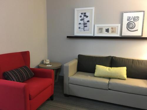 a living room with a couch and a chair at Country Inn & Suites by Radisson, Camp Springs Andrews Air Force Base , MD in Camp Springs