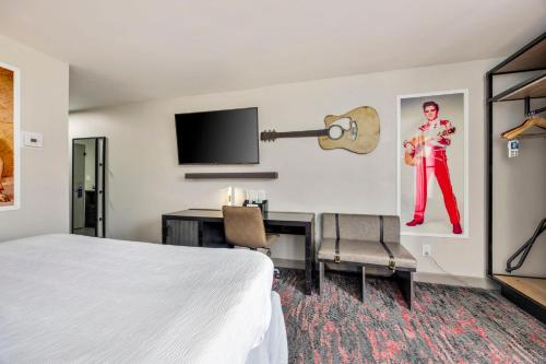 a hotel room with a bed and a desk with a guitar at Best Western Downtown PLUS Music Row in Nashville