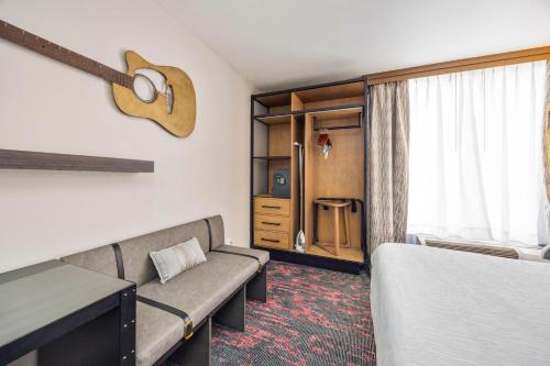 a hotel room with a bed and a couch at Best Western Downtown PLUS Music Row in Nashville