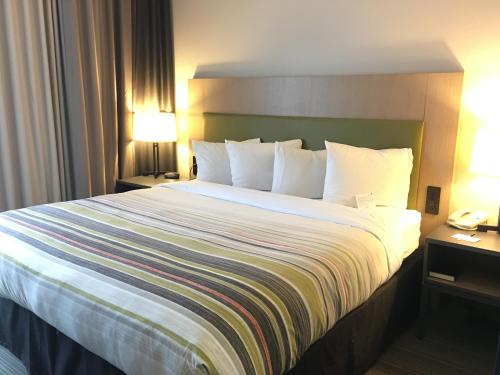 a large bed in a hotel room with two lamps at Country Inn & Suites by Radisson, Camp Springs Andrews Air Force Base , MD in Camp Springs