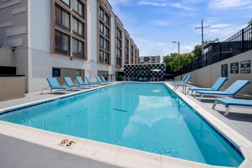 a swimming pool with lounge chairs and a building at Best Western Downtown PLUS Music Row in Nashville