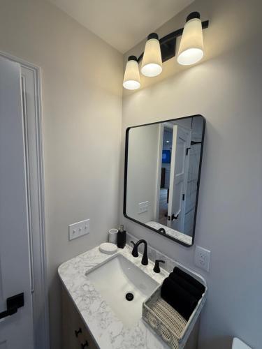 a bathroom with a sink and a large mirror at Boston First floor condo in Framingham