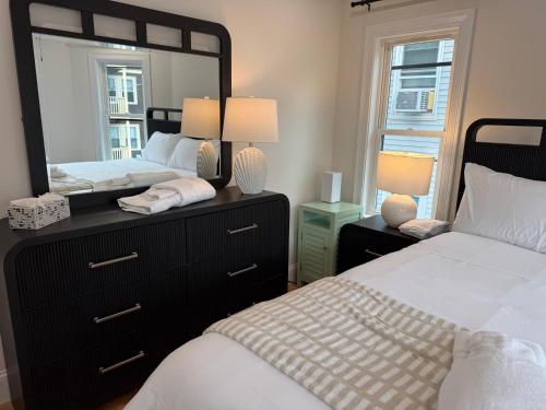 a bedroom with two beds and a large mirror at Boston First floor condo in Framingham