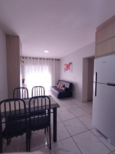 a kitchen with a table and chairs and a refrigerator at Confortável Apto de 2 Quartos - Lagoa Quente in Caldas Novas