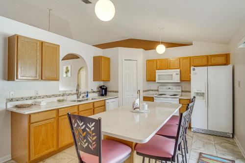 a kitchen with a white refrigerator and a table with chairs at 15 Mi to Melbourne Beach Peaceful Palm Bay Escape in Palm Bay