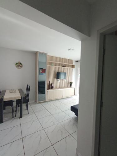a living room with a table and a television at Confortável Apto de 2 Quartos - Lagoa Quente in Caldas Novas