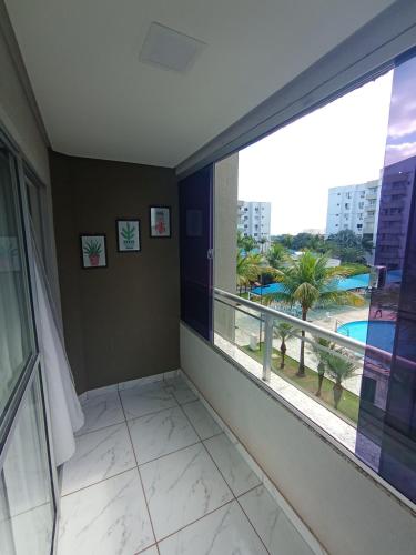 a room with a large window with a view of a resort at Confortável Apto de 2 Quartos - Lagoa Quente in Caldas Novas